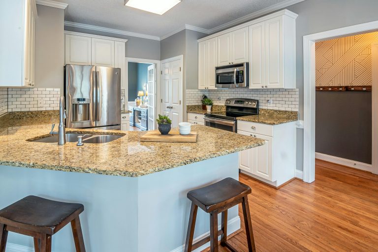 Professional sealing a marble countertop with specialized equipment.