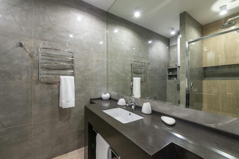 Sealing marble countertop in a kitchen and bathroom to protect against stains.