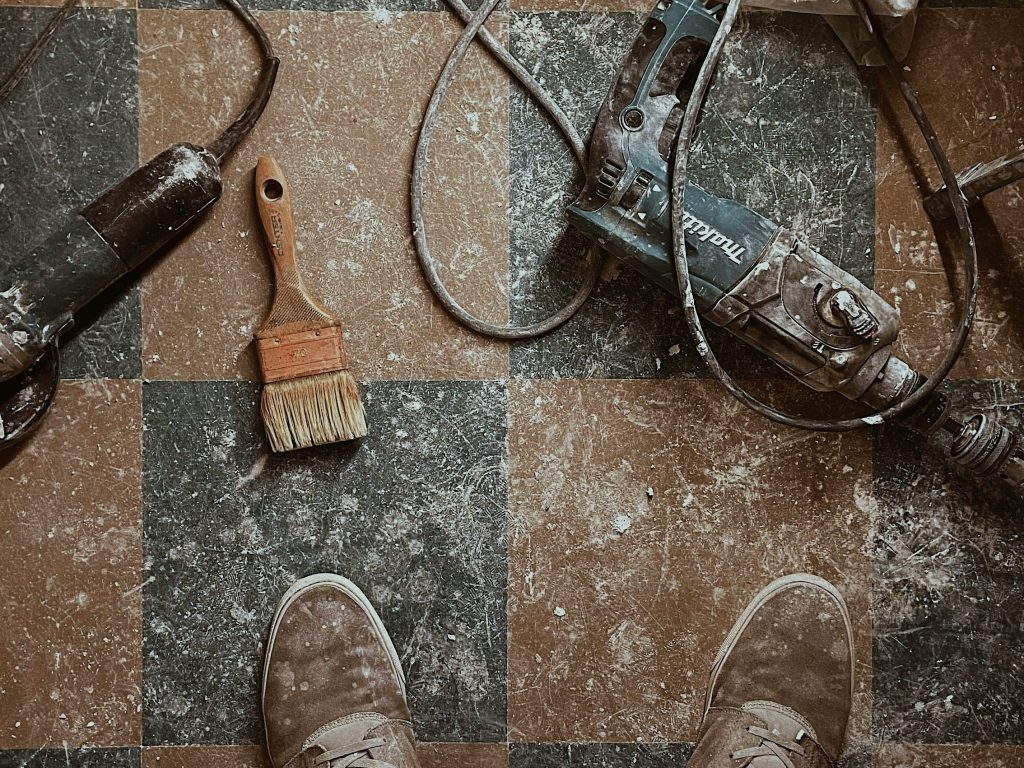A professional floor technician using a diamond grinding to restore a natural stone surface